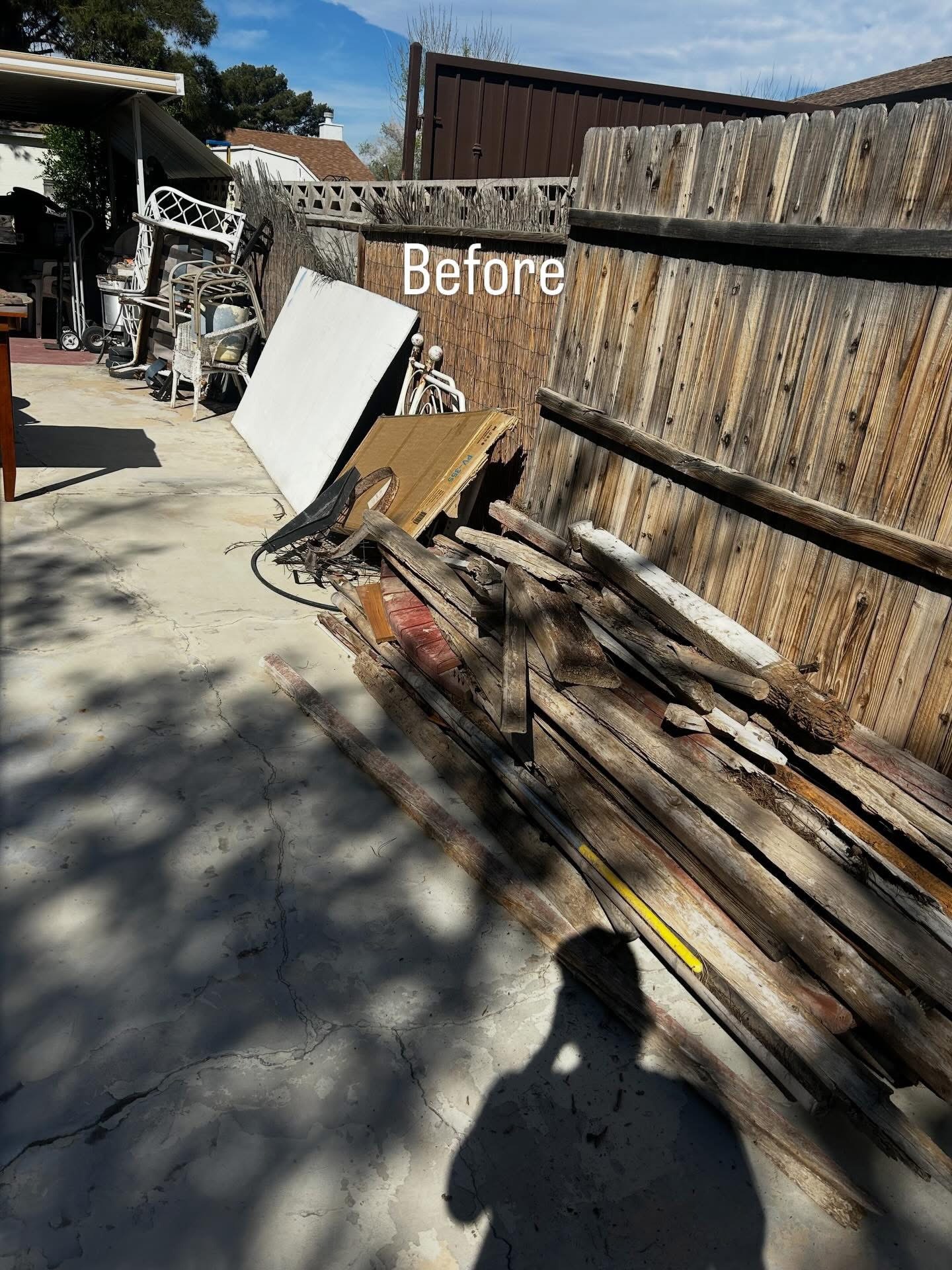 Yard debris stacked along a fence before removal
